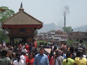 Image from Kathmandu showing people walking and a brick kiln in the background